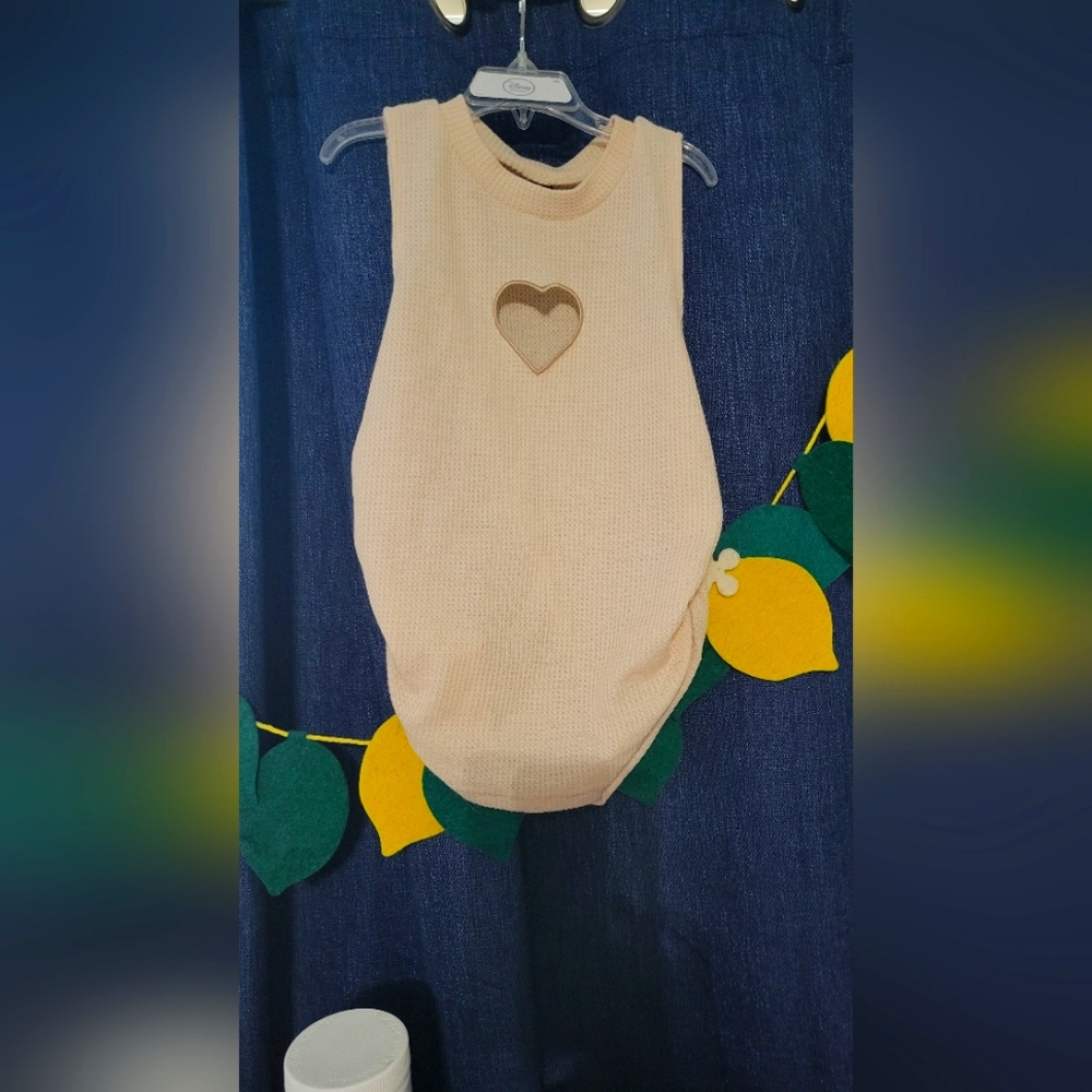 Cream colored shirt with heart hole. Sleeveless